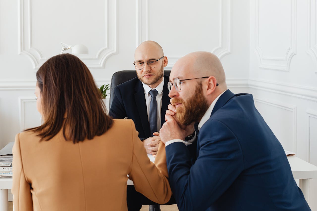 hero-img-02 Lawyers consulting with clients in a modern office setting, discussing legal matters.